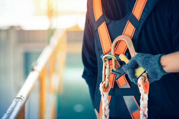 Construction worker wearing safety harness and safety line working at high place